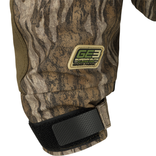 Close-up of the Guardian Elite™ LST Insulated Timber Jacket, highlighting camouflage knee pad, black strap, and durable fabric. Designed for hunters with practical features.