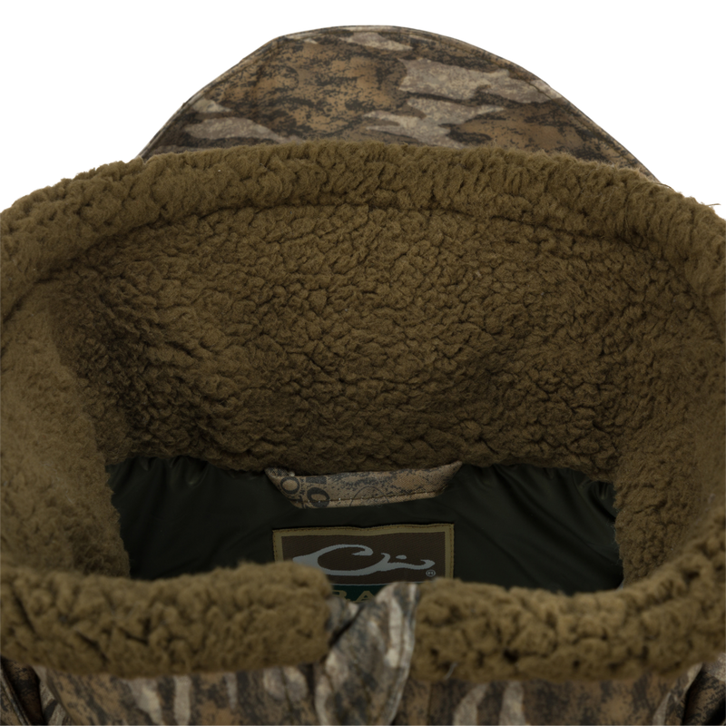 Close-up of the Guardian Elite™ LST Insulated Timber Jacket, showcasing the durable fabric, reinforced stitching, and logo detail, designed for waterfowl hunting.