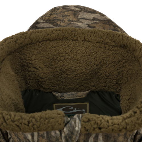 Close-up of the Guardian Elite™ LST Insulated Timber Jacket, showcasing the durable fabric, reinforced stitching, and logo detail, designed for waterfowl hunting.