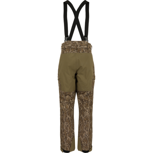 MST Waist-High Insulated Bibs with suspenders, featuring water-resistant zippers, cargo pockets, and reinforced knees, designed for optimal warmth and mobility in hunting conditions.