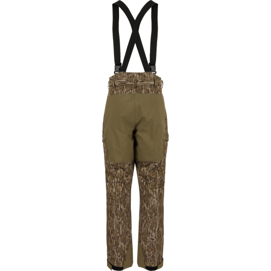 MST Waist-High Insulated Bibs with suspenders, featuring water-resistant zippers, cargo pockets, and reinforced knees, designed for optimal warmth and mobility in hunting conditions.