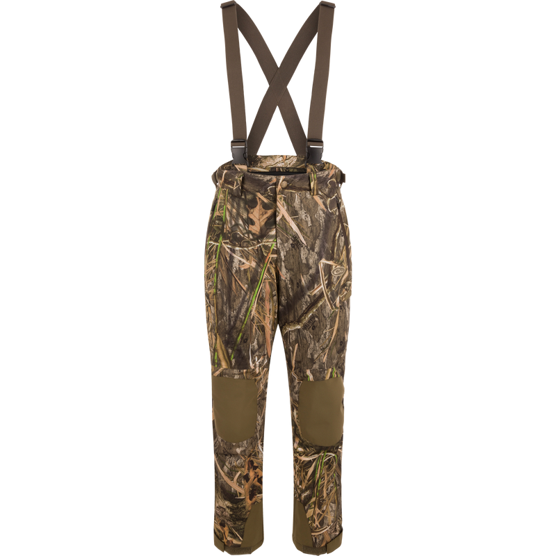 MST Waist-High Insulated Bibs with camouflage pattern, suspenders, and multiple zippered pockets for secure storage; designed for hunting with waterproof, insulated material.