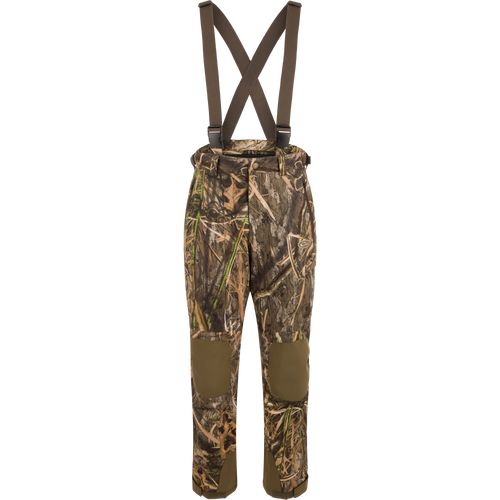 MST Waist-High Insulated Bibs with camouflage pattern, suspenders, and multiple zippered pockets for secure storage; designed for hunting with waterproof, insulated material.