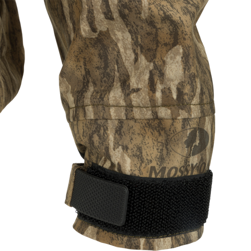 Close-up of G3 Flex Uninsulated Waterfowlers Jacket's camouflage sleeve, black strap, and patch, highlighting its rugged, waterproof fabric and durable design.