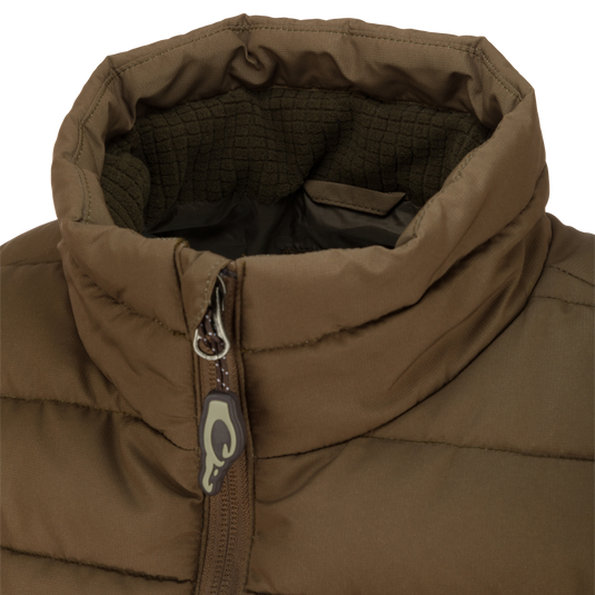 Close-up of the LST Double Down Layering Vest showcasing the zipper and logo, highlighting its durable, insulated design and microfleece-lined collar for added warmth.