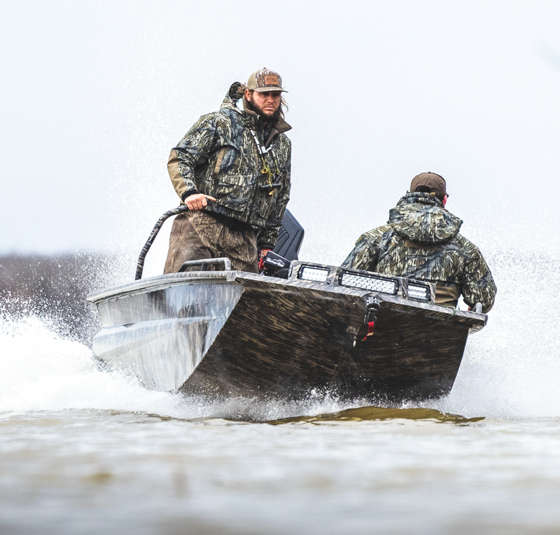 Men wearing the Guardian Elite™ LST Insulated Timber Jacket on a boat, showcasing its practical design and features for hunting.