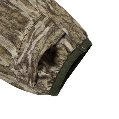 Close-up of the Half Zip Pullover with Spider Web Technology, showcasing the camouflage fabric and ergonomic thumbholes designed for turkey hunting.