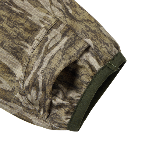 Close-up of the Half Zip Pullover with Spider Web Technology, showcasing the camouflage fabric and ergonomic thumbholes designed for turkey hunting.