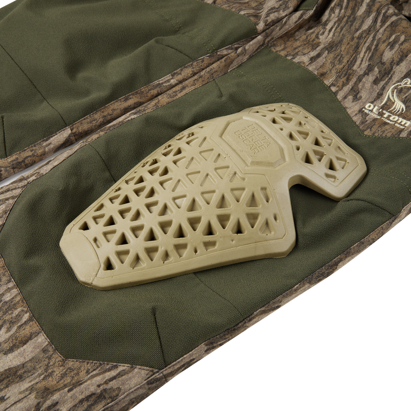 Early Bird Turkey Pant with Insect Repellent, featuring camouflaged design and durable polyester, shown on a textured surface, highlighting its protective and breathable features for hunters.