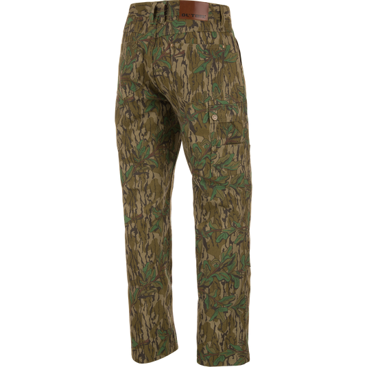 Throwback 80 Field Pant featuring camouflage design, durable cotton twill, reinforced knees, and antique brass riveted pockets, ideal for hunting and outdoor activities.