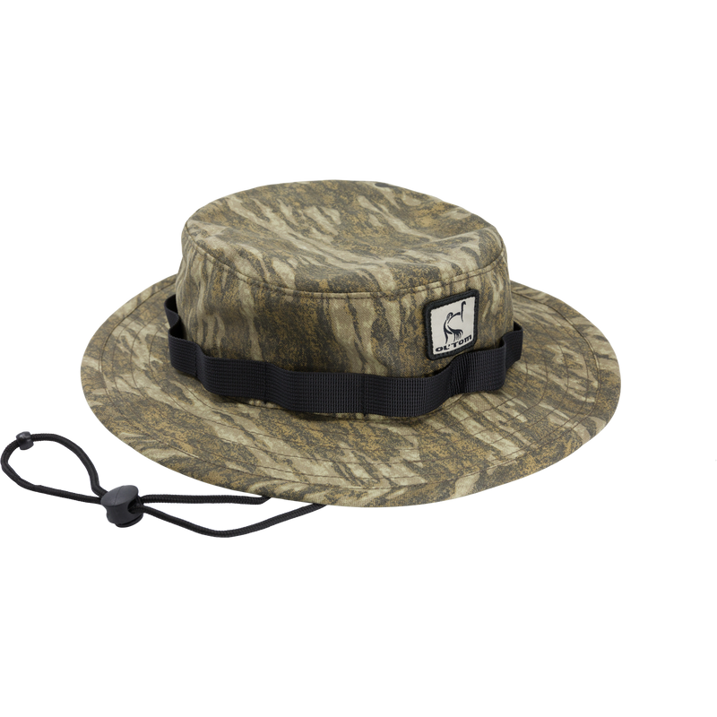 DUK Boonie Hat featuring a camouflage pattern, adjustable black strap, and full brim for sun protection, made from durable 100% cotton DUK fabric.