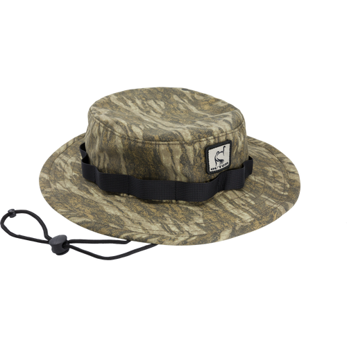 DUK Boonie Hat featuring a camouflage pattern, adjustable black strap, and full brim for sun protection, made from durable 100% cotton DUK fabric.