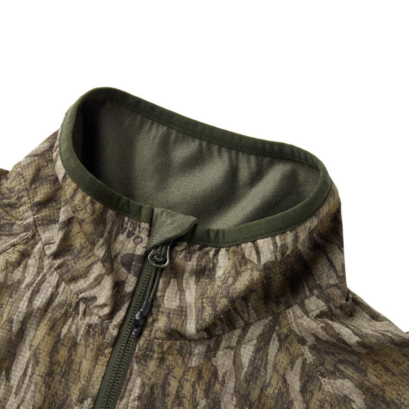 Eqwader Half Zip Pullover featuring a close-up of the water-resistant YKK zipper and ergonomic thumbholes, showcasing breathable and durable spider web technology for hunting apparel.