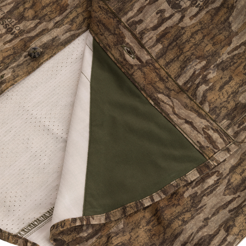 Men's Camo Wingshooter Trey Shirt L/S close-up showing camouflage fabric, button, and hidden zippered pocket with Magnattach closure, emphasizing technical features and performance fabric.