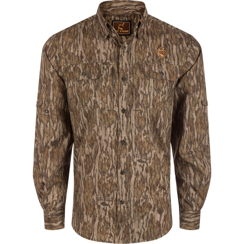 Men's Camo Wingshooter Trey Shirt with tree pattern, featuring long sleeves, button-down collar, and chest pockets, designed for performance and comfort in hunting environments.