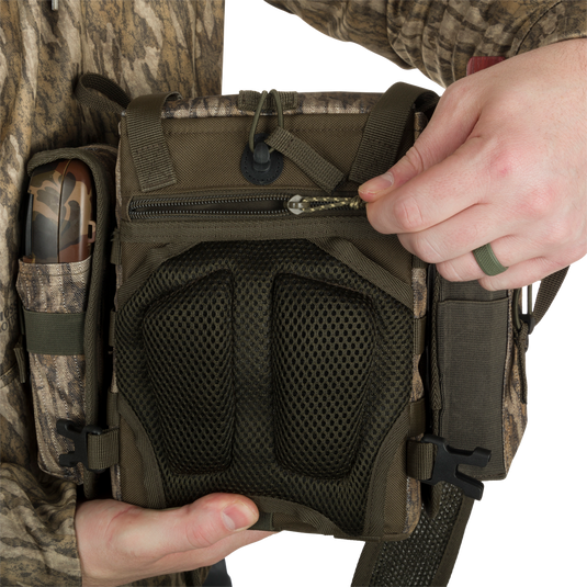 Run-N-Gun Turkey Chest Pack held by person, showcasing durable design with multiple pockets, removable bino harness, and secure zippered compartments.