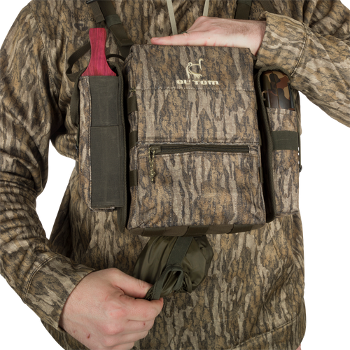 Run-N-Gun Turkey Chest Pack held by a person, featuring multiple pockets and a detachable bino harness, ideal for hunting trips with lightweight durability.