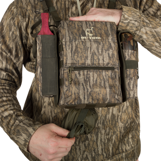 Run-N-Gun Turkey Chest Pack held by a person, featuring multiple pockets and a detachable bino harness, ideal for hunting trips with lightweight durability.