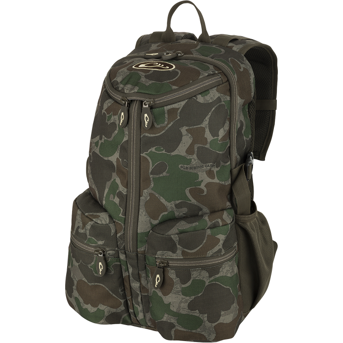 A compact and functional Vertical Zip Daypack, perfect for hunting or everyday use. Features include padded shoulder straps, large interior storage, external carry straps, and hydration bladder compartment. Made with 100% Polyester Rugged HD2™ Material and Drake’s Fowl-Proof™ YKK Zippers. Dimensions: 18.5