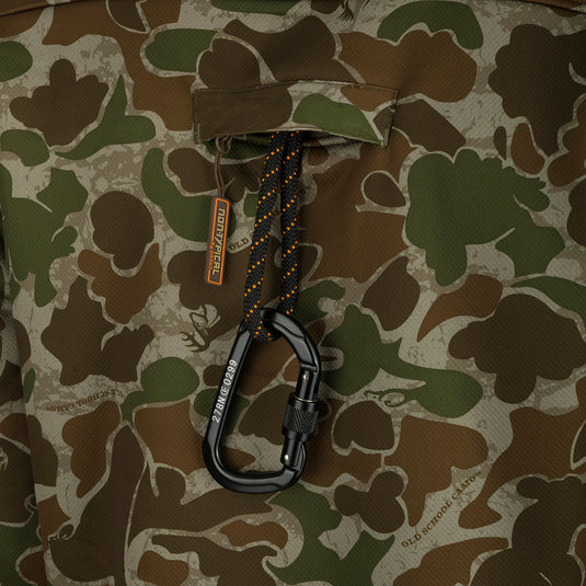 Close-up of a Youth Silencer Full Zip Jacket Full Camo with Agion Active XL, featuring a carabiner attached to a lanyard in a chest pocket.