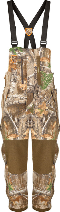 HydroHush Midweight Bib with Agion Active XL, featuring camouflage shorts with multiple zippered pockets, Velcro leg closures, and black suspenders adorned with a logo.