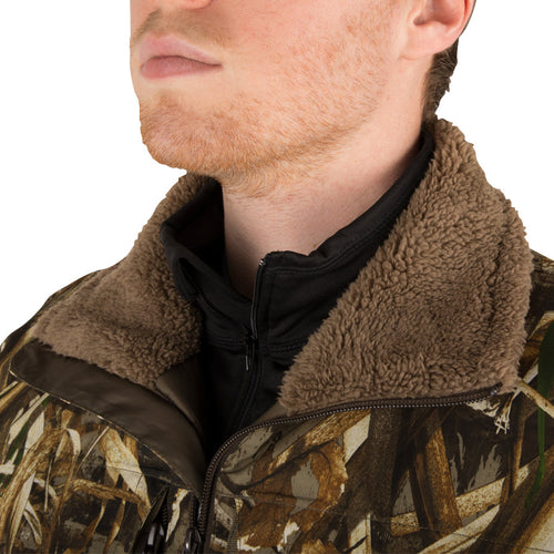 Man wearing the LST Guardian Flex Double Down Eqwader Full Zip Jacket with Hood, showcasing its camouflage design and advanced waterfowl hunting features.